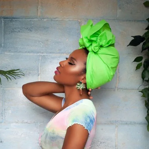 Foulard vert vif porté en turban wrap sur cheveux relevés, coiffure bohème