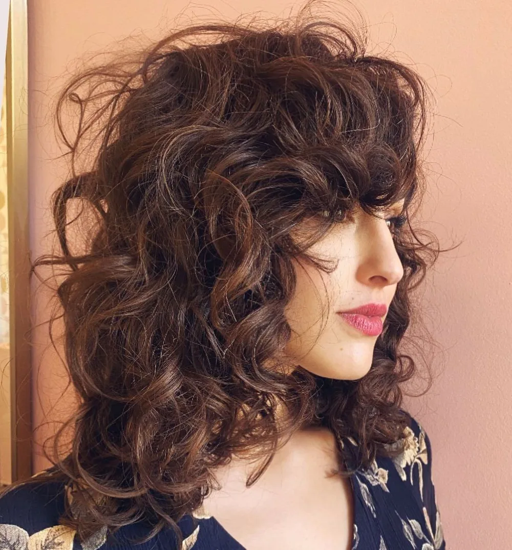 Grosses boucles décoiffées volumineuses avec frange bouclée sur cheveux épais