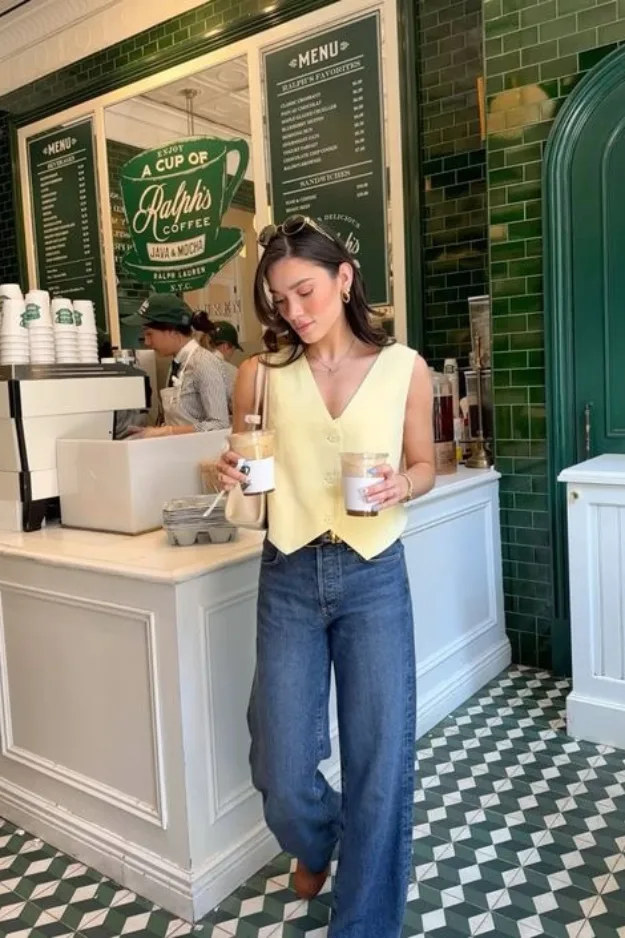 Jean large droit porté avec un gilet jaune pâle et des bottines camel