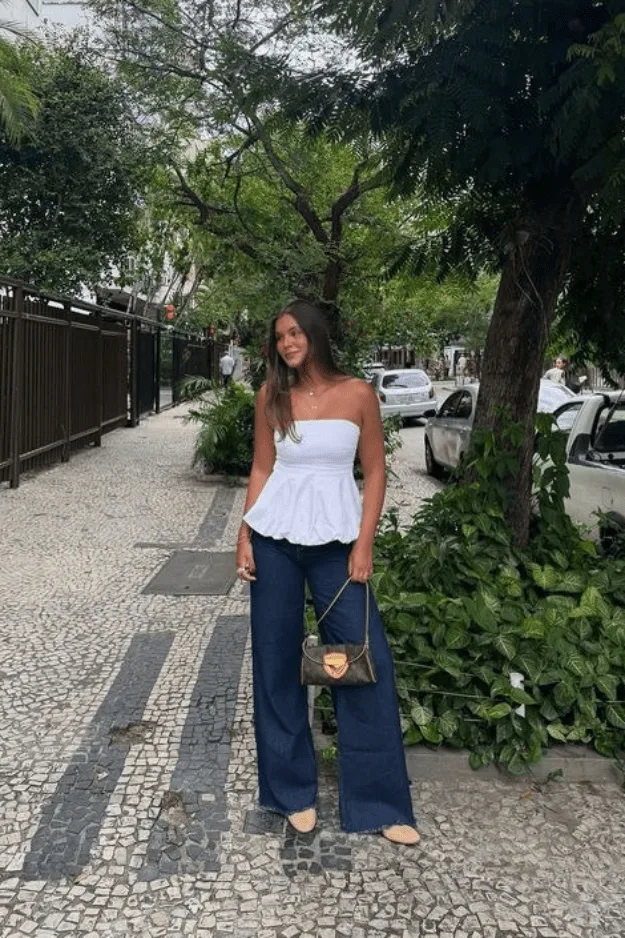 Jean large foncé porté avec un bustier blanc smocké