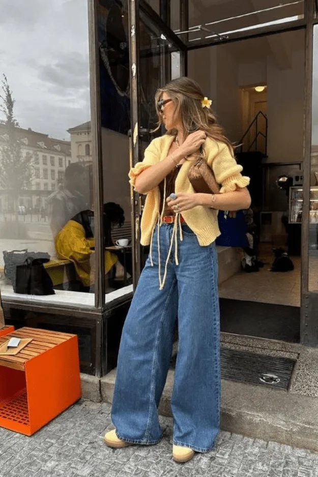 Jean large porté avec un cardigan jaune à volants et une ceinture colorée