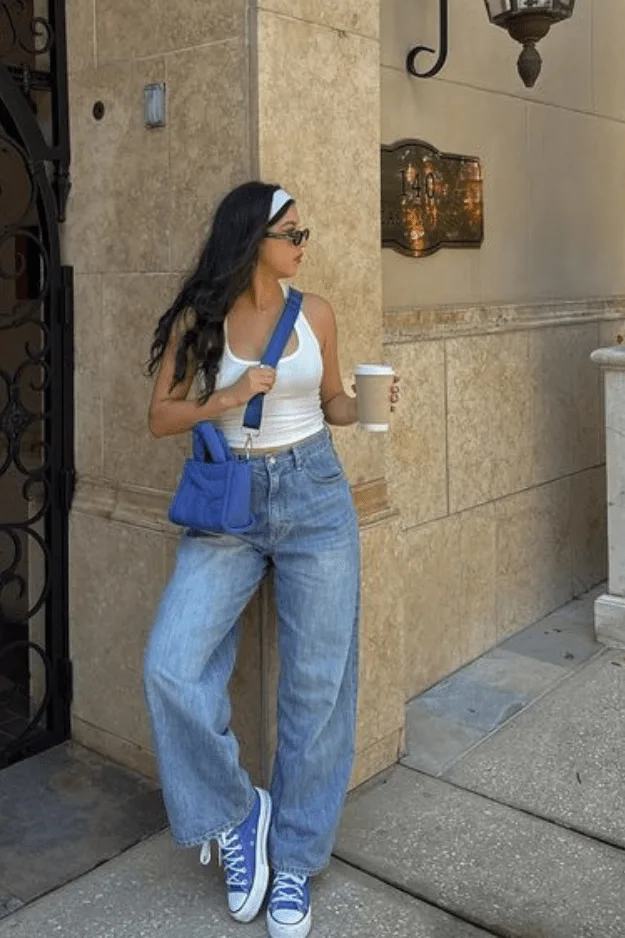 Jean large porté avec un top blanc et des accessoires bleu cobalt