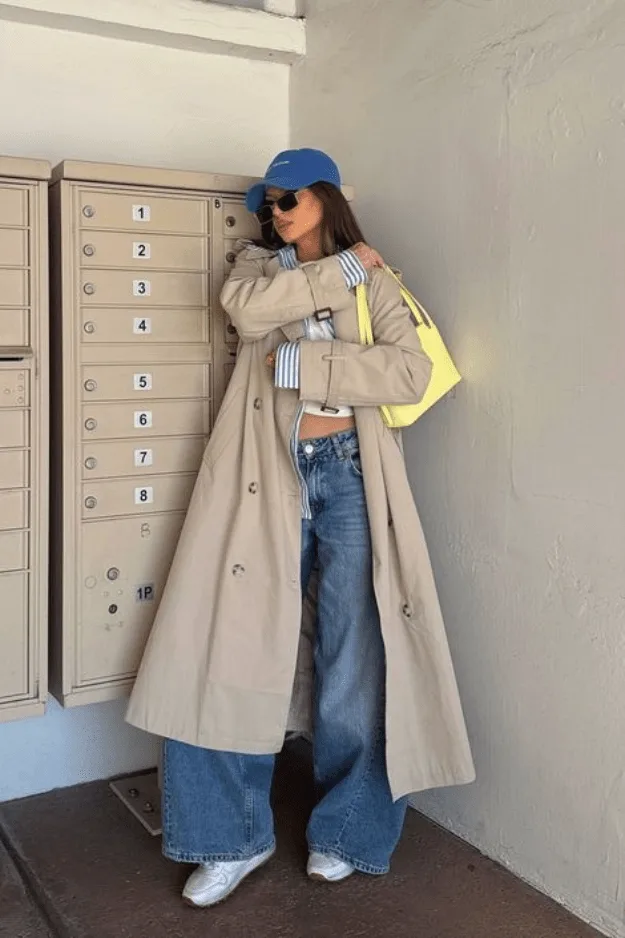 Jean large porté avec un trench camel long et des baskets blanches