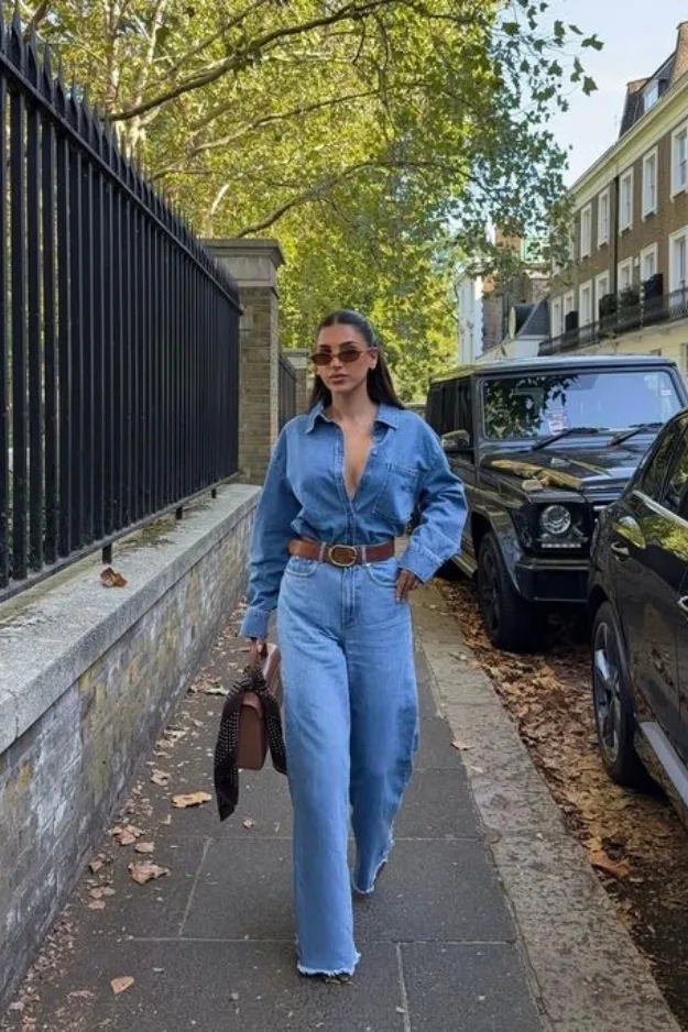 Jean large porté avec une chemise en jean ouverte et ceinturée