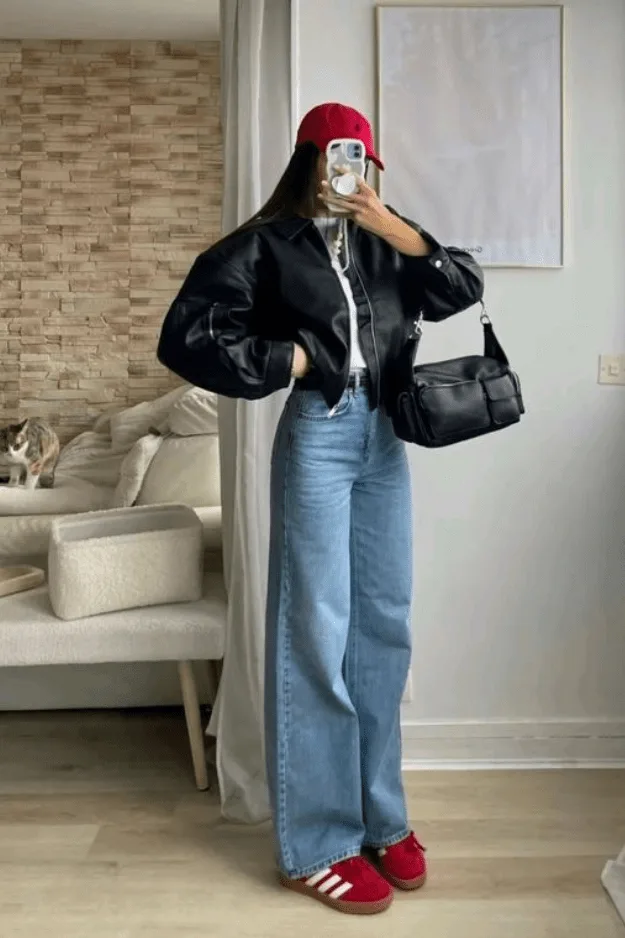 Jean large porté avec une veste en cuir, un béret rouge et des baskets rouges