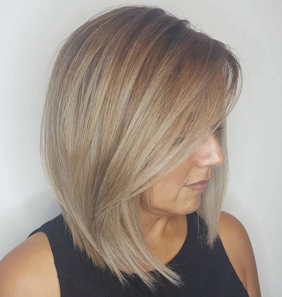 Lob ash blond avec root fade et longue frange balayée swoopy