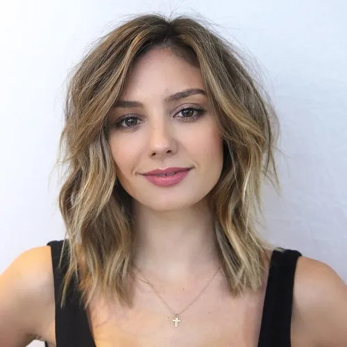 Lob dégradé blond foncé aux mèches effilées qui adoucissent un visage carré