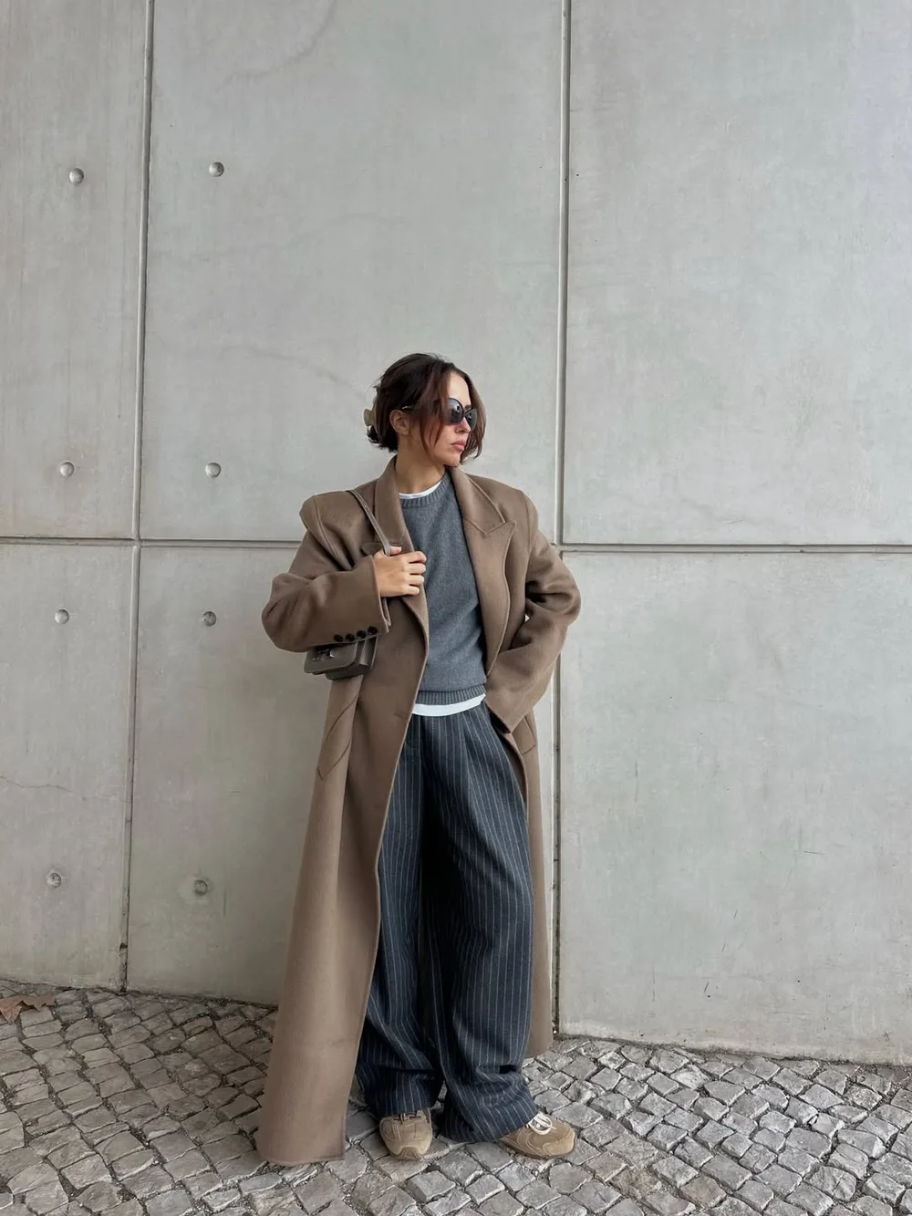 Long manteau camel porté avec un pull et un pantalon fluide