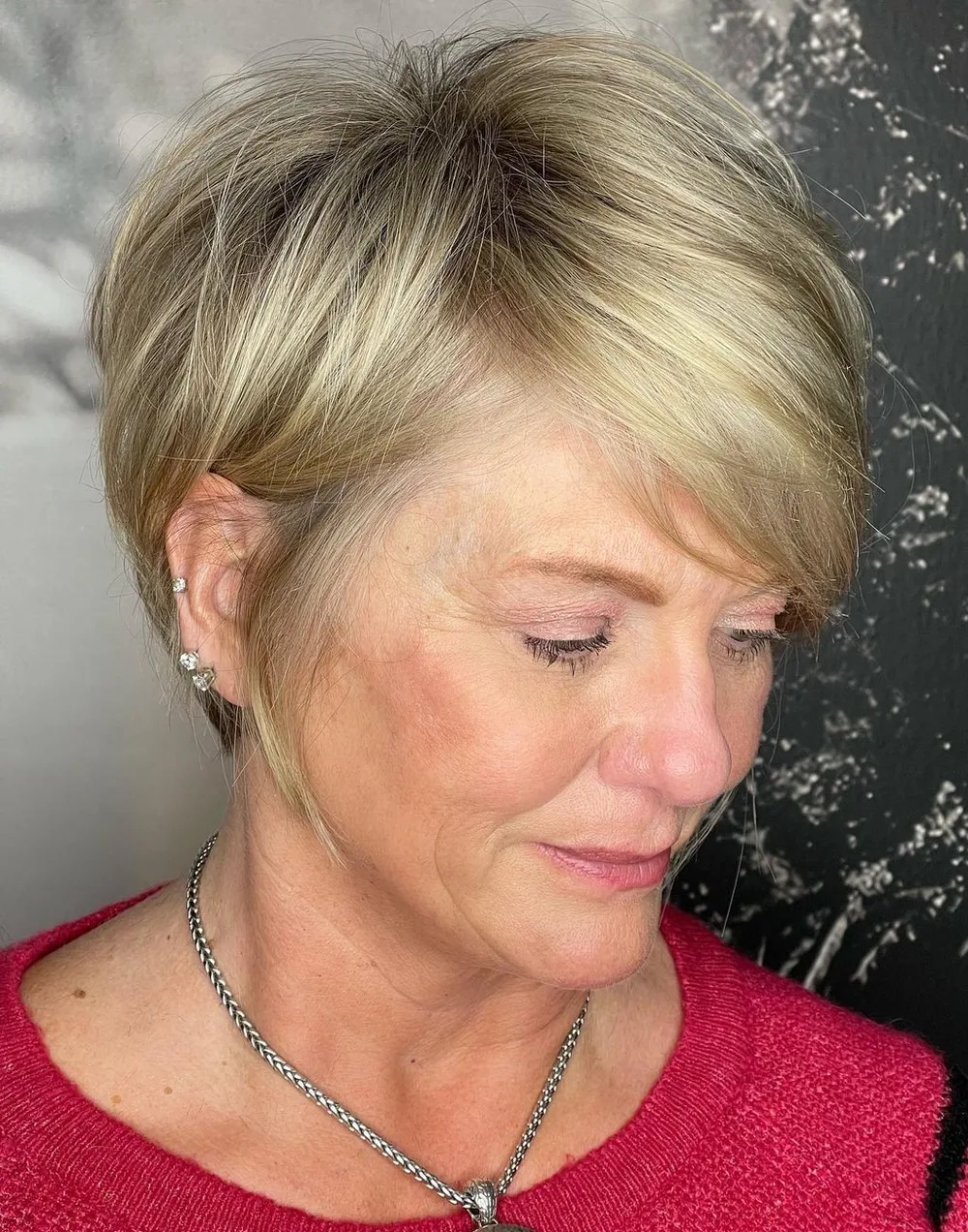Long pixie blond avec nuque fuselée et frange balayée sur le côté