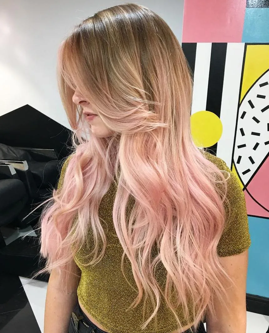 Longs cheveux bronde avec balayage rose subtil et boucles souples