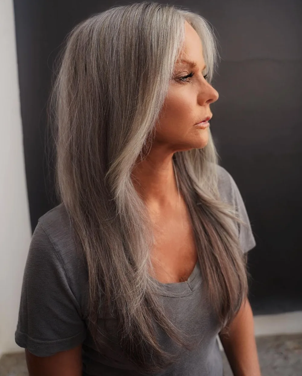 Longs cheveux gris naturels en couches sur femme de plus de 50 ans