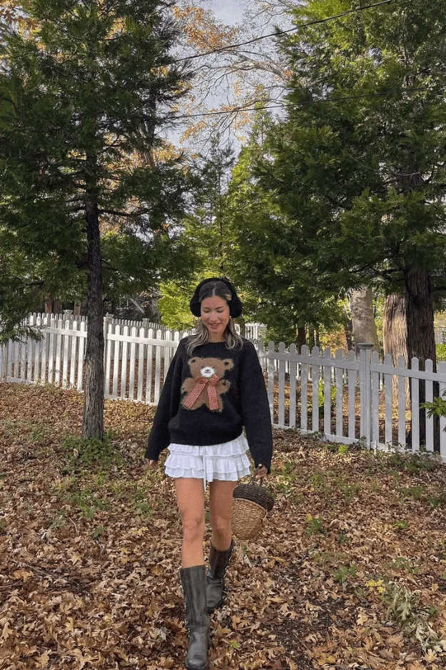 Look automne mini-jupe blanche à volants avec sweat graphique noir et bottes