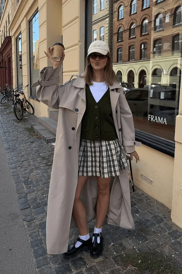 Look automne trench beige et gilet olive sur jupe midi à carreaux avec plateformes