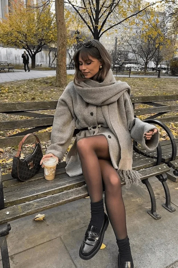 Look manteau beige oversize à capuche avec collants marron et mocassins noirs