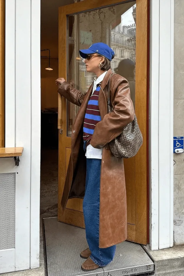Look manteau long en cuir bicolore avec casquette bleue et chemise rayée