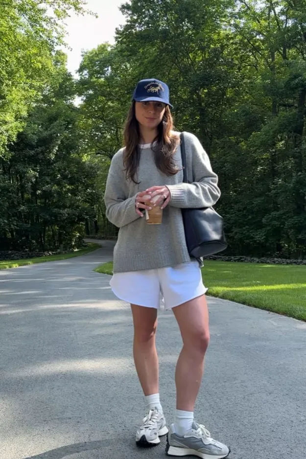 Look sweat gris avec casquette et short blanc et baskets pour la rentrée