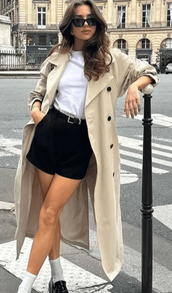 Look trench beige avec top blanc, short noir et baskets pour la mi-saison