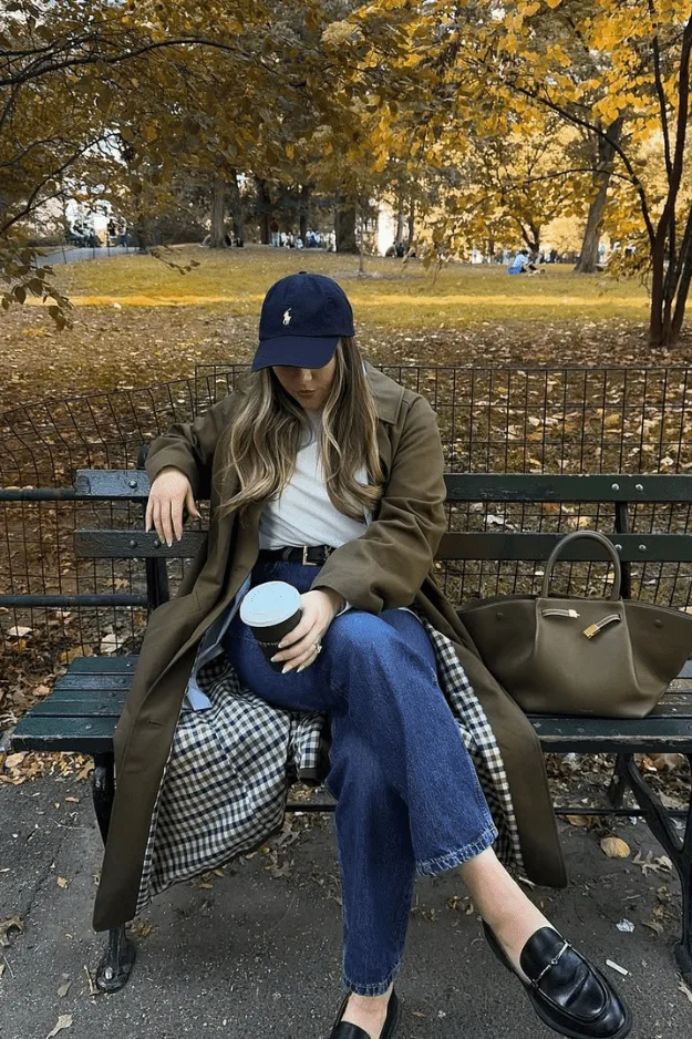 Look trench kaki oversize, tee-shirt blanc, jean marine, mocassins et casquette
