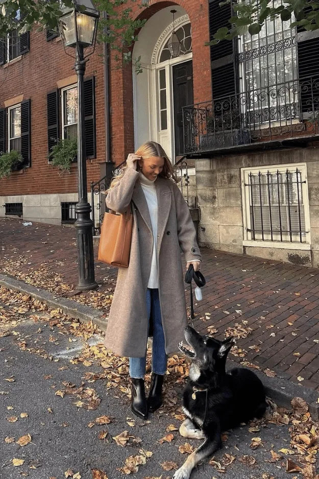 Look trench taupe, tee-shirt blanc, jean bleu, bottes noires et sac orange vif