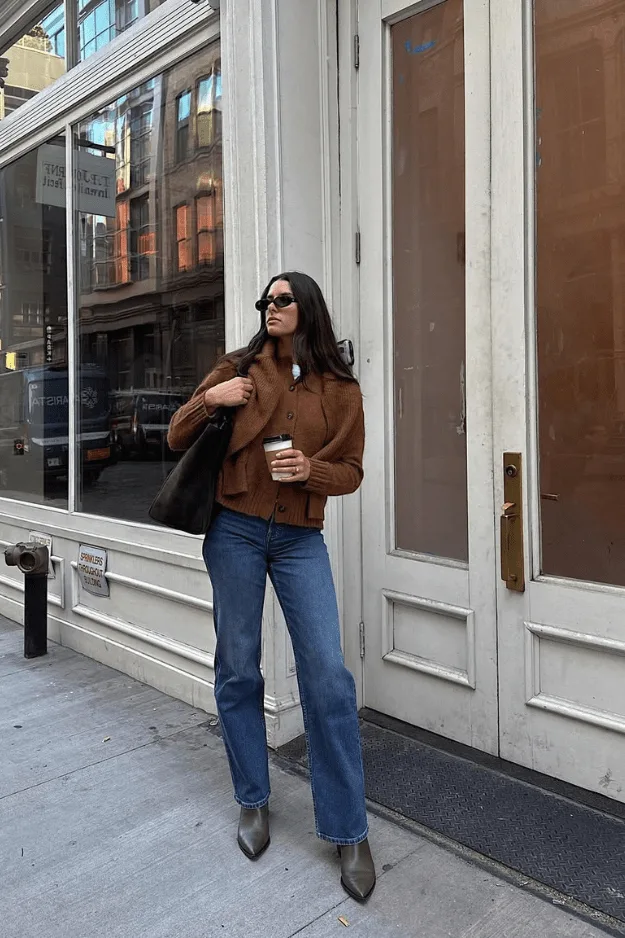 Look veste courte structurée marron avec jean droit bleu et bottes en daim