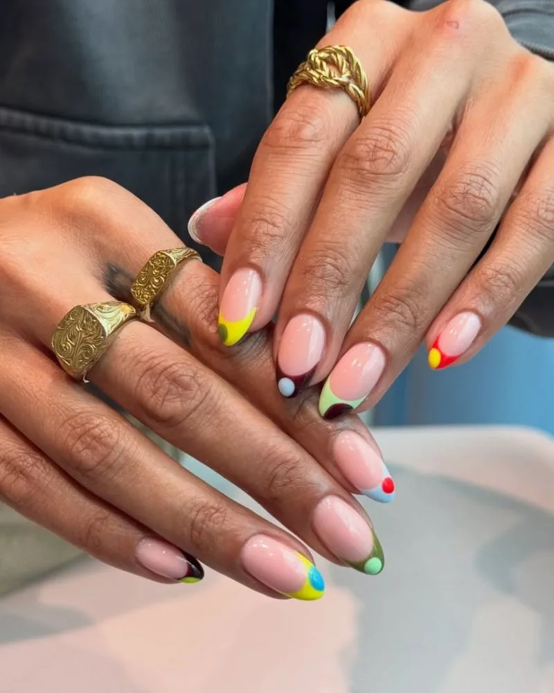 Manucure french abstraite avec pops de couleur aux coins et pointes sur base nude