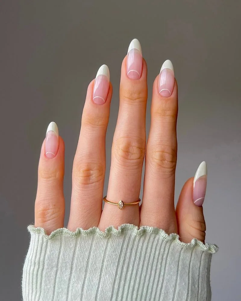 Manucure french blanche classique sur ongles amande avec fine ligne blanche courbée