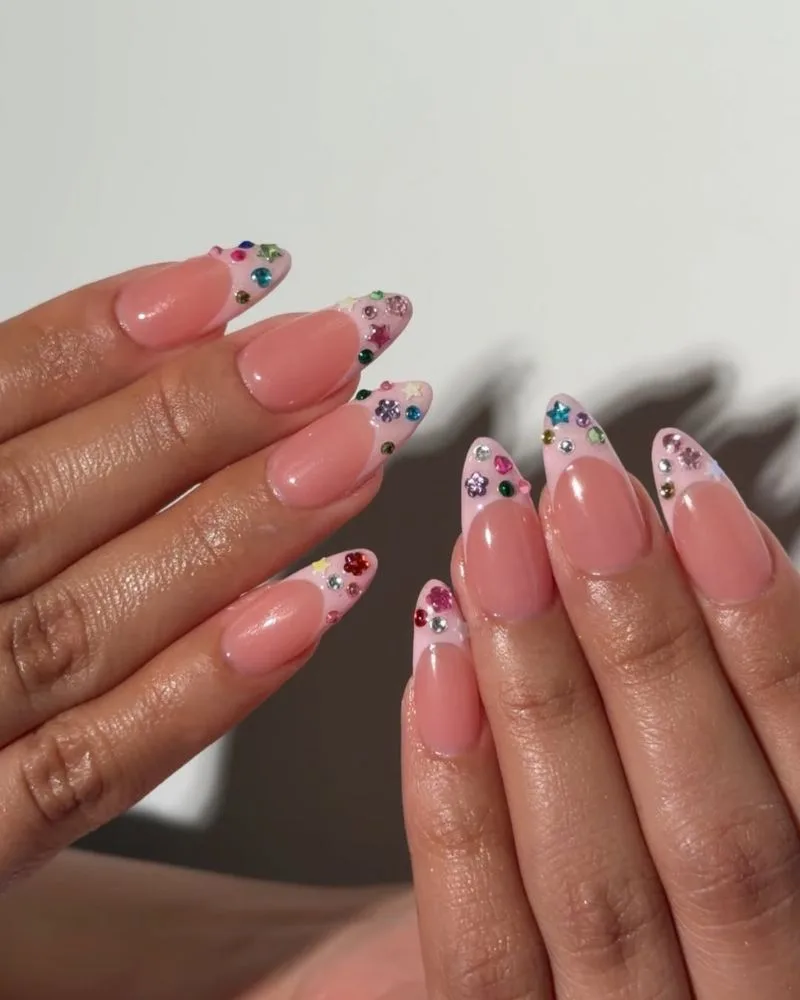 Manucure french rose chaud avec strass multicolores sur les pointes, ongles amande