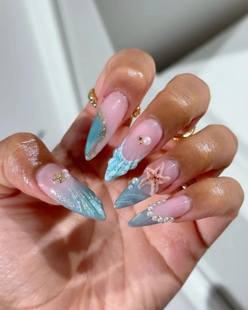 Manucure french stiletto effet océan cat eye bleu avec étoile de mer et perles 3D