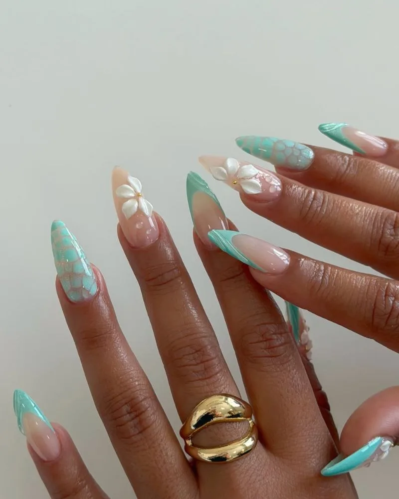Manucure french turquoise texturée avec fleurs blanches 3D sur ongles amande nude