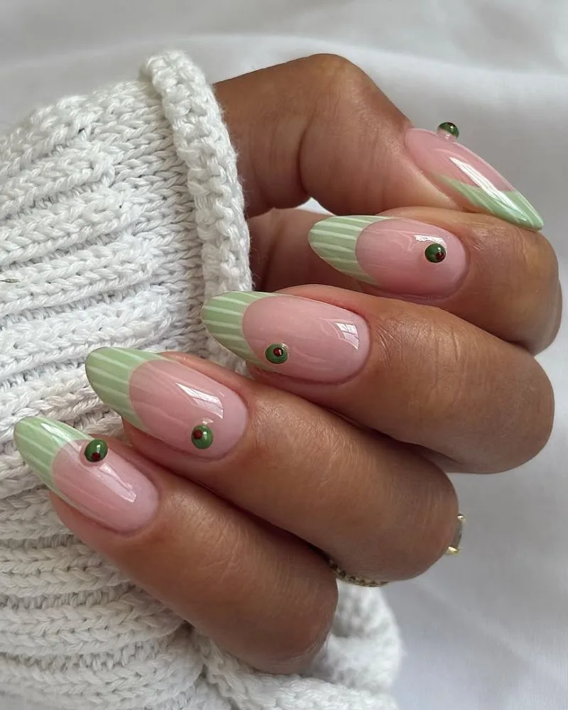 Manucure french vert sauge rayée avec olive 3D sur base nude, ongles amande