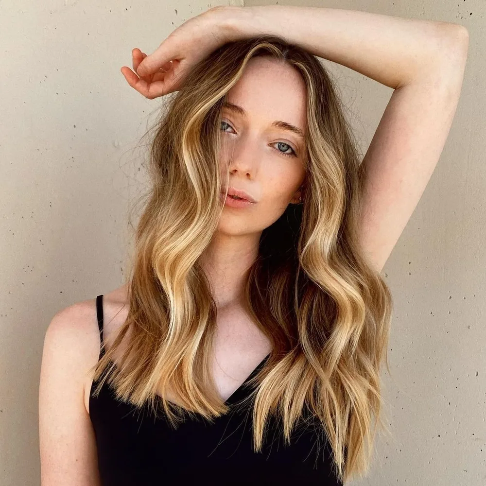 Mèches blond miel encadrantes sur base blond foncé, peau claire