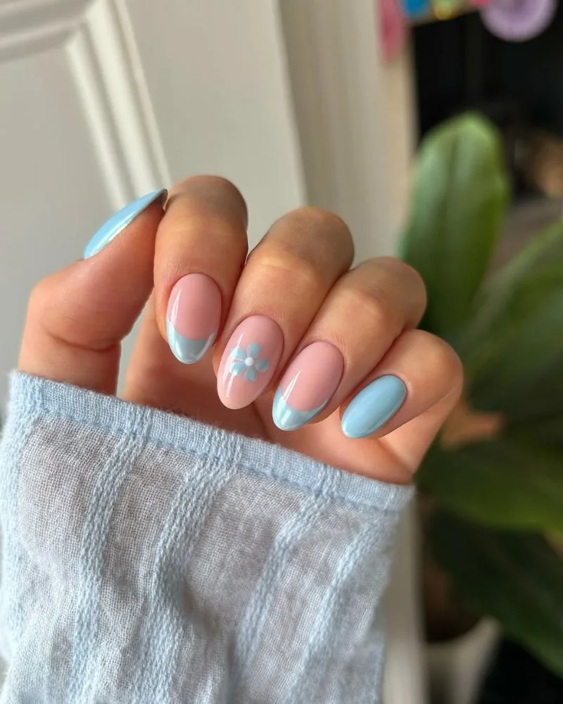 Ongles amande bleu clair avec touche de chrome et petite fleur, manucure d'été