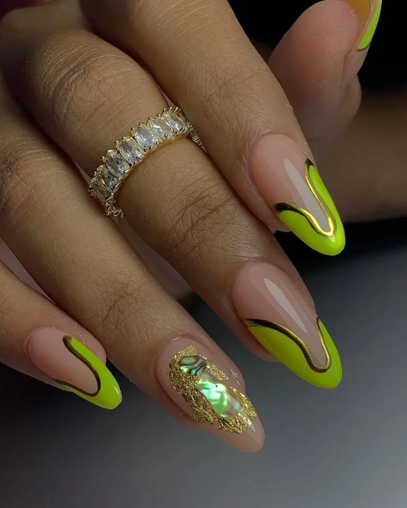 Ongles amande néon vert sur base nude avec accents dorés et paillette