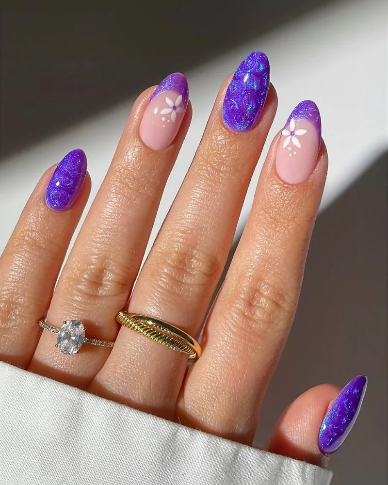 Ongles amande violet œil-de-chat pailleté avec swirl et fleurs, nail art d'été