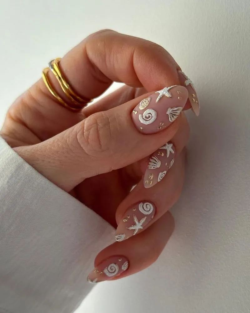 Ongles base nude mate avec coquillages et étoiles de mer peints, nail art plage élégant