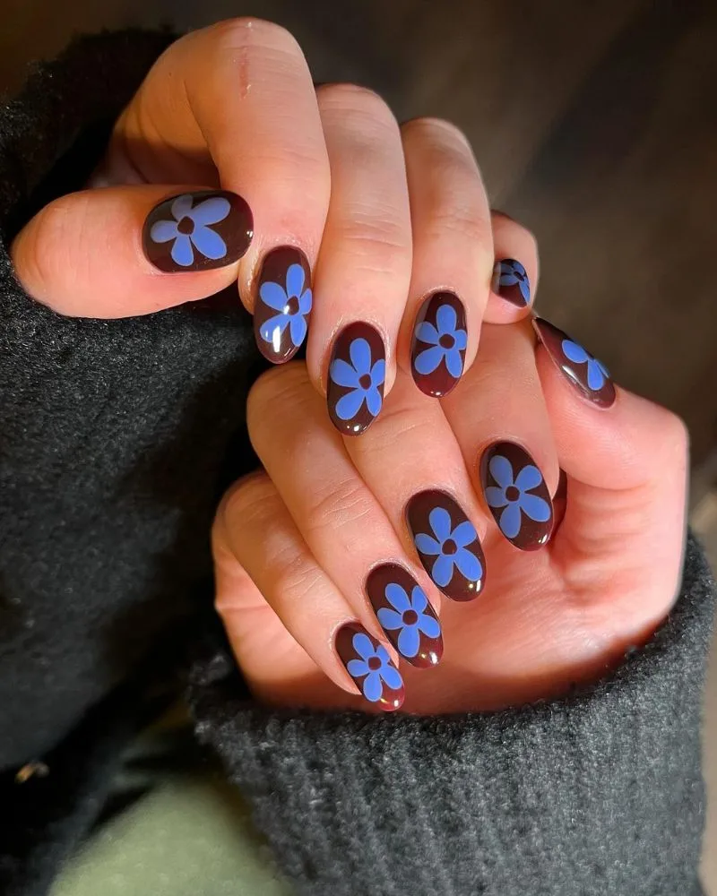 Ongles chocolat avec petites marguerites bleues