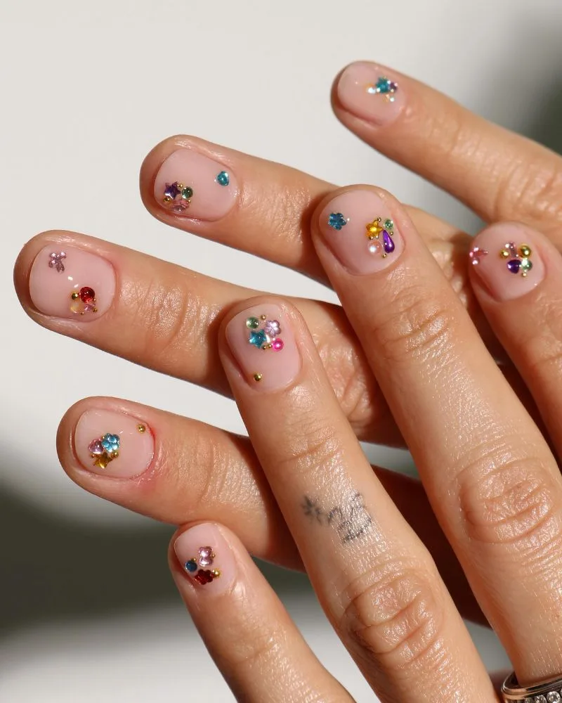 Ongles nude ornés d'une grappe de strass colorés