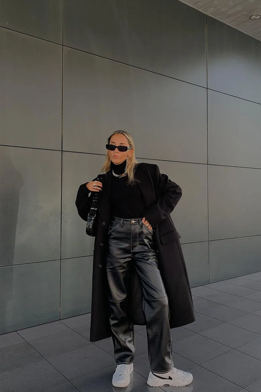 Pantalon en cuir porté avec un col roulé et des baskets