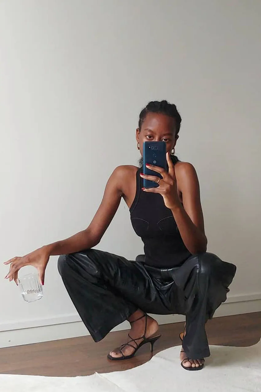 Pantalon en cuir porté avec un haut noir minimaliste
