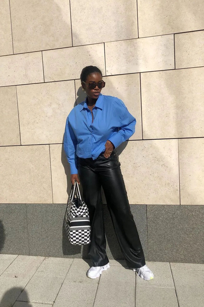 Pantalon en cuir porté avec une chemise bleue rentrée