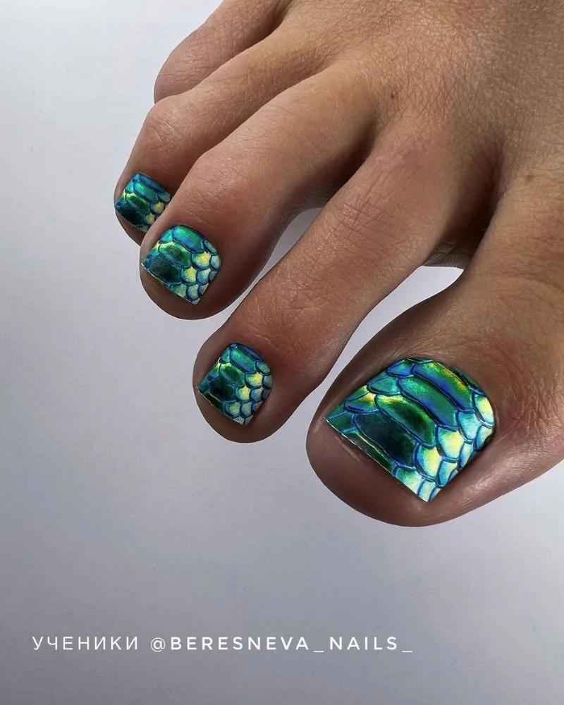 Pédicure effet écailles de reptile bleu et teal sur les orteils, nail art audacieux