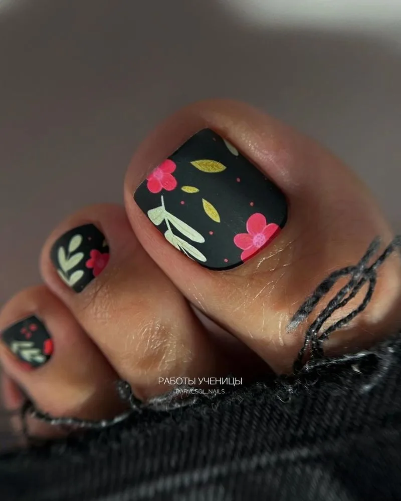 Pédicure élégante fleurs colorées sur base noire, nail art floral d'été