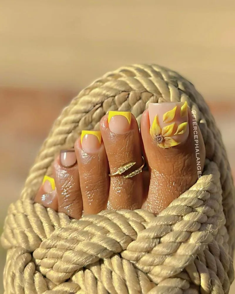 Pédicure french jaune avec tournesol 3D sur le gros orteil, nail art d'été