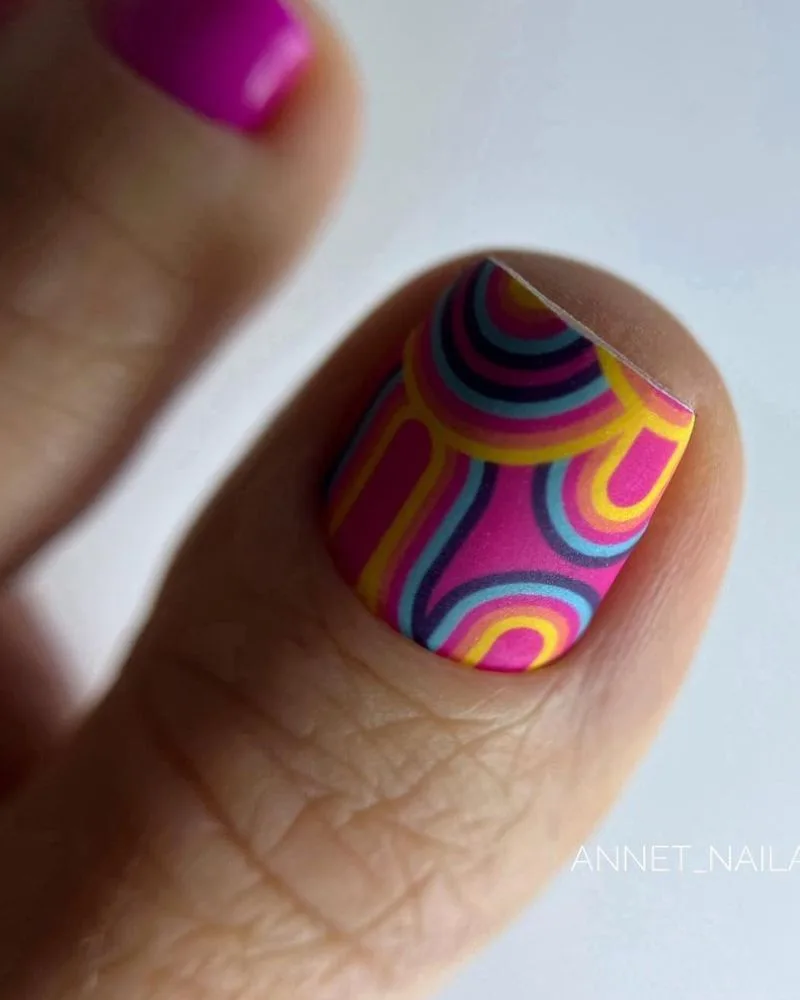 Pédicure fuchsia vif avec accent swirl multicolore sur le gros orteil