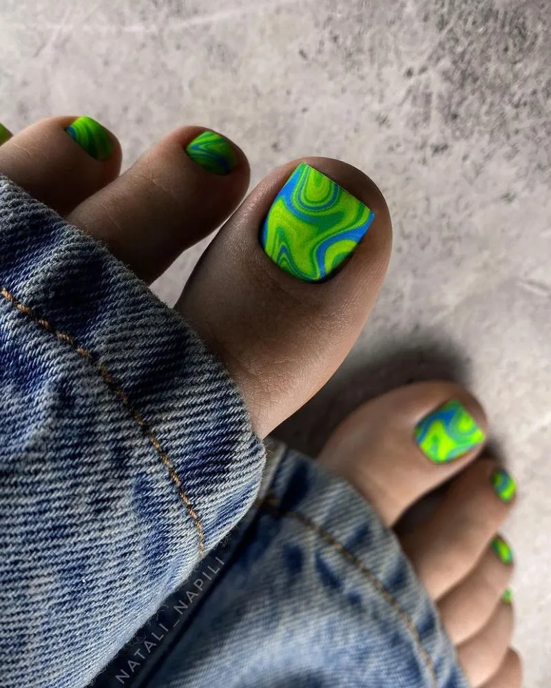 Pédicure inspirée de l'aurore boréale en vert et bleu avec nail art fluide
