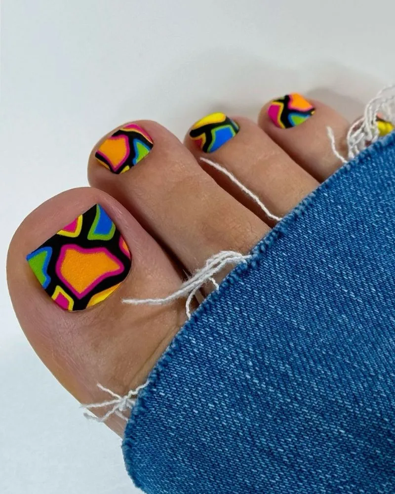 Pédicure motifs géométriques abstraits multicolores sur les orteils