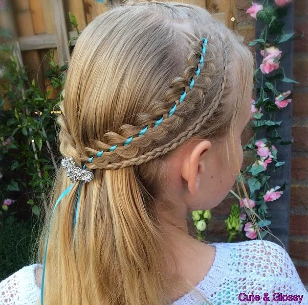 Petite fille avec demi-attache, tresses fines et ruban coloré tissé