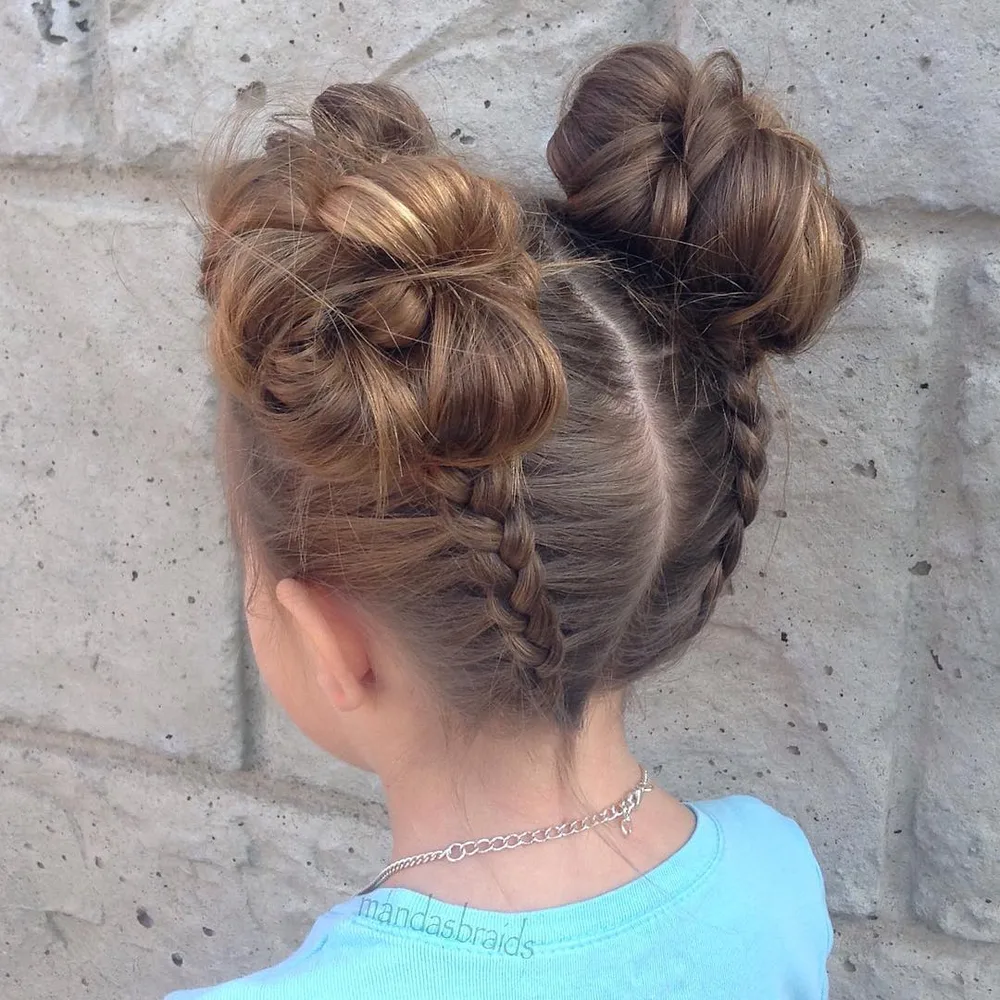 Petite fille avec deux dutch braids torsadées en chignons volumineux