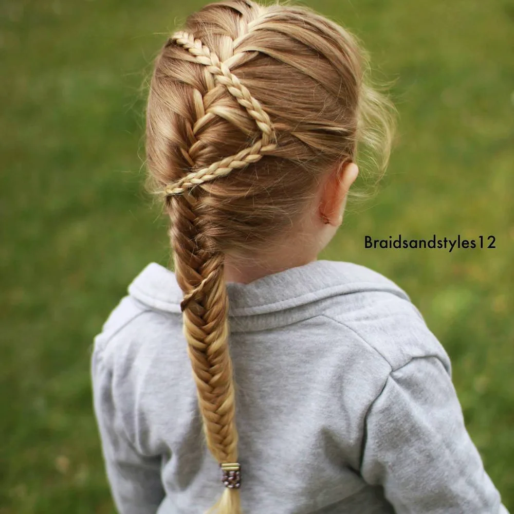 Petite fille avec tresse française se poursuivant en fishtail sur cheveux longs