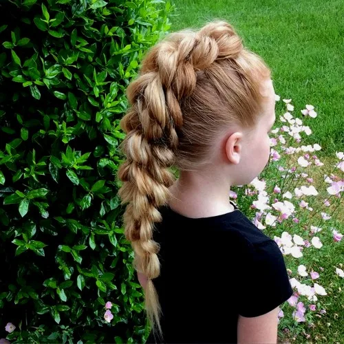 Petite fille avec tresse mohawk inversée sur cheveux épais, coiffure originale